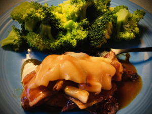 chicken with bacon, pineapples, and provolone on a plate with steamed broccoli